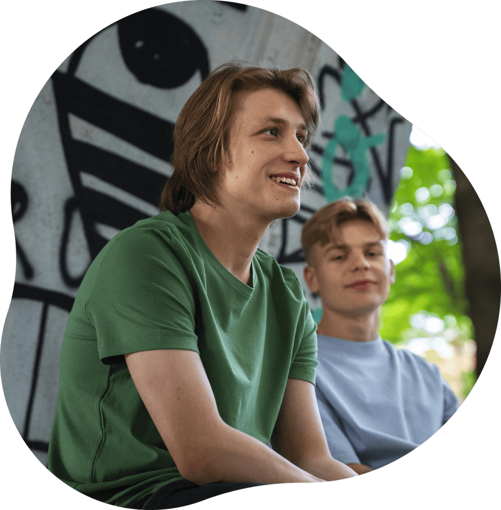 Twee jonge mannen praten en lachen in een park in Nijmegen.